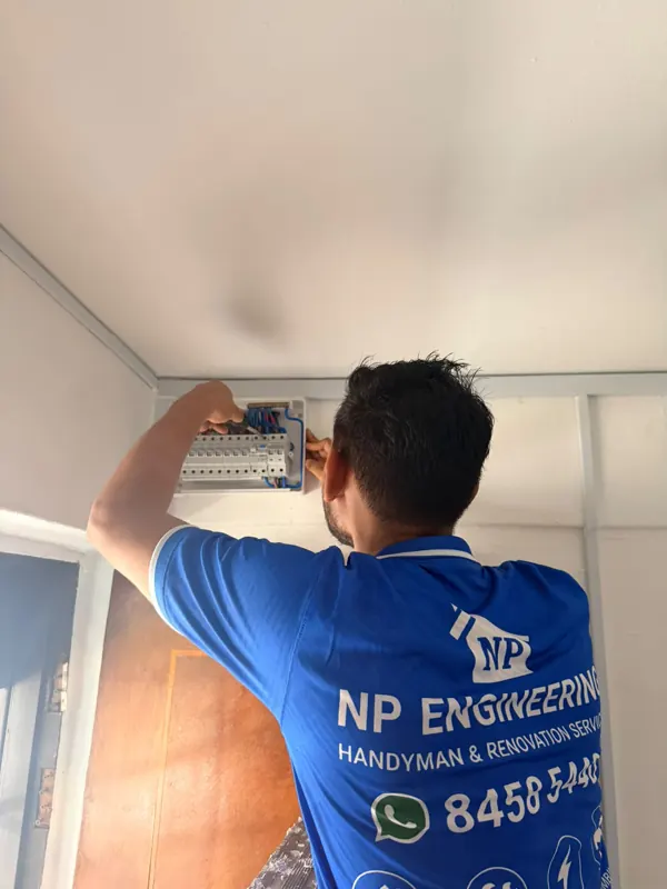 NP Engineering technician working on a wall-mounted distribution board at Blk 233 Lorong 8 Toa Payoh