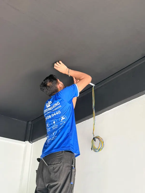 NP Engineering technician fitting wiring near the ceiling at Blk 233 Lorong 8 Toa Payoh